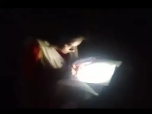 Student giving exam by lighting mobile torch