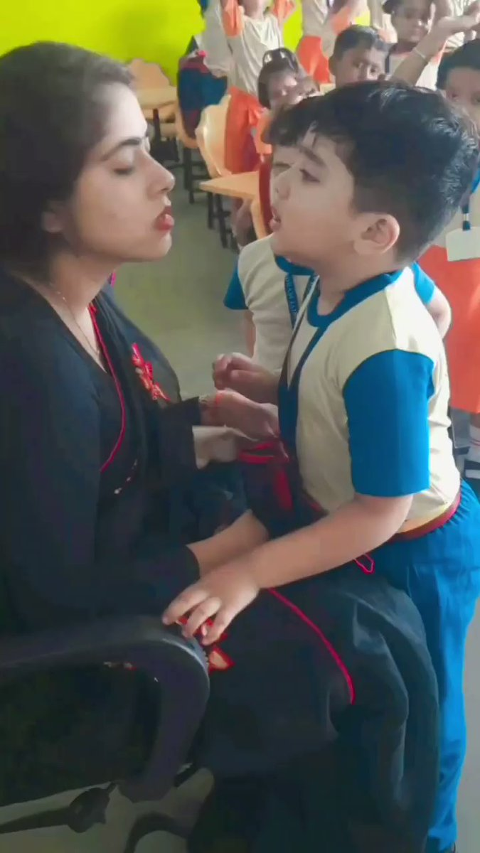 In the video, the teacher is seen talking to a small child.
